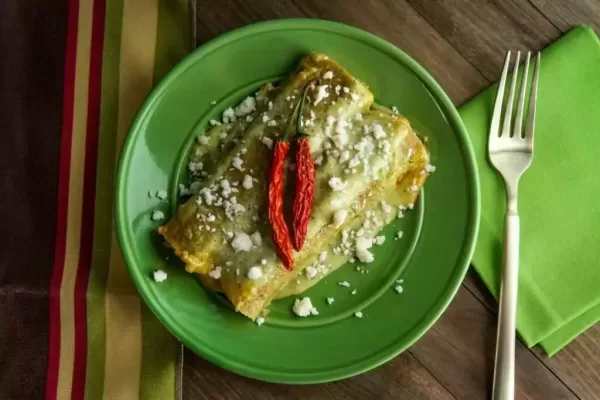 Mexican enchiladas with creamy poblano pepper sauce and queso fresco cheese