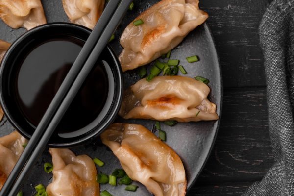 flat lay traditional asian dish with chopsticks dumplings