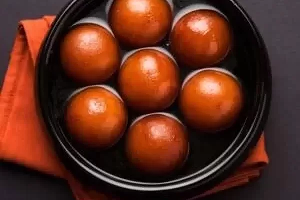 Sweet Gulab Jamun served in black ceramic bowl